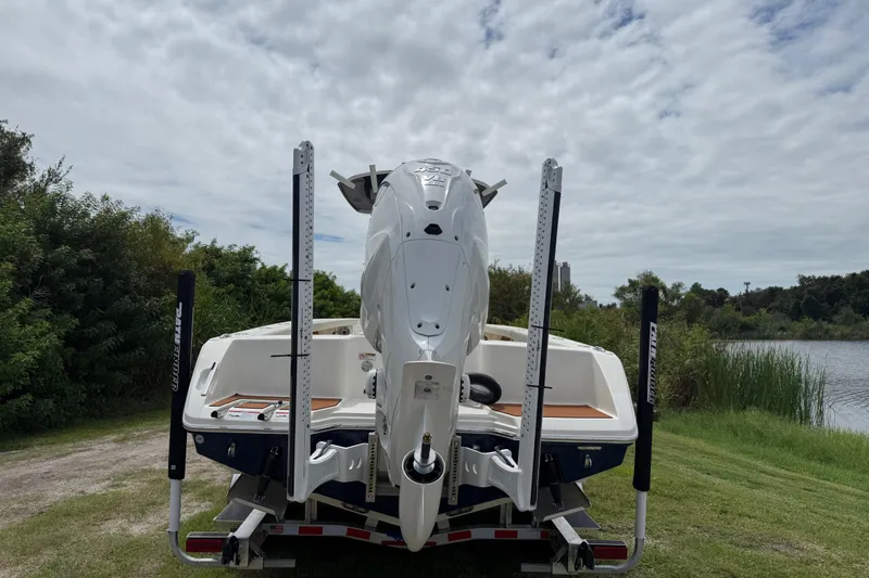 Slide: The Image of 2026 Pathfinder 2700 Open boat on trailer by a lake, rear view. - 3