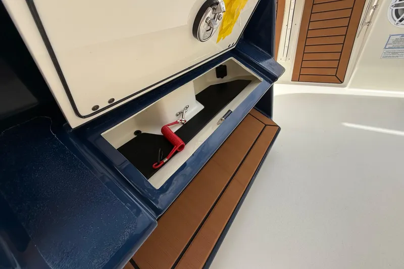 Slide: The Image of 2026 Pathfinder 2700 Open boat storage compartment with red safety lanyard. - 36