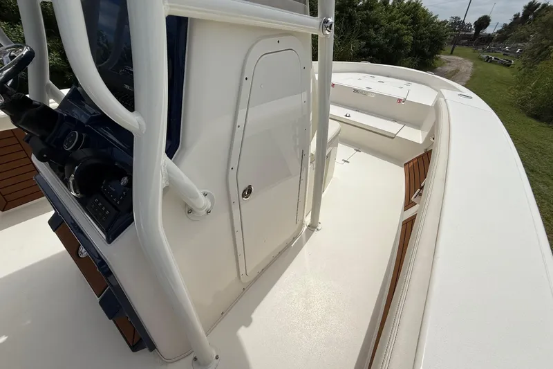 Slide: The Image of 2026 Pathfinder 2700 Open boat deck with console and seating, surrounded by greenery. - 41