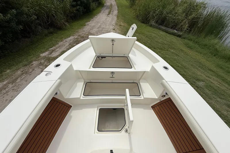 Slide: The Image of 2026 Pathfinder 2700 Open boat with open storage compartments, docked near grassy shoreline. - 43