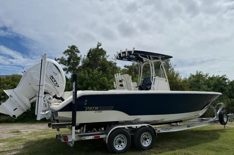 Slide: The Image of 2026 Pathfinder 2700 Open boat on trailer, parked outdoors under cloudy sky. - 6
