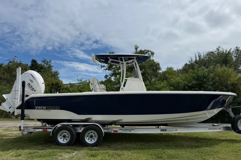 Slide: The Image of 2026 Pathfinder 2700 Open boat on trailer, parked outdoors under cloudy sky. - 7