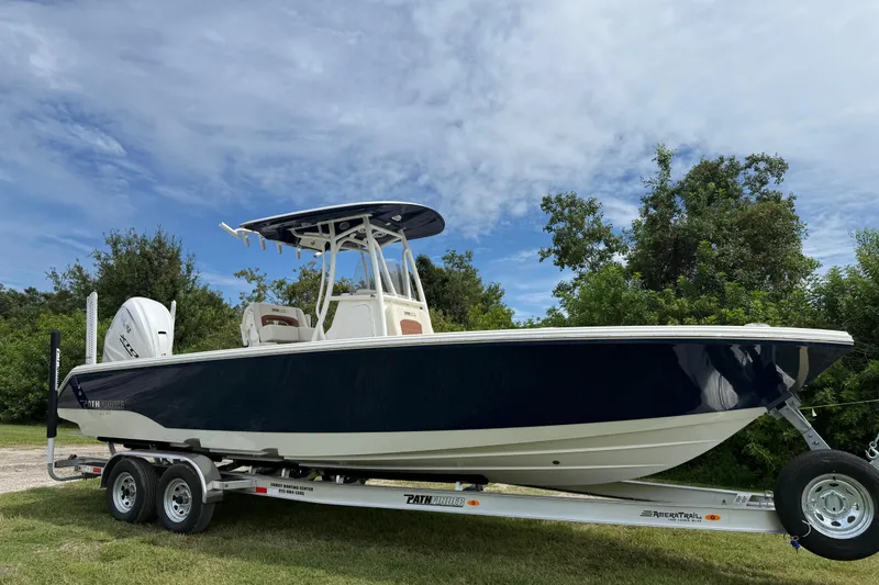 Slide: The Image of 2026 Pathfinder 2700 Open boat on trailer, parked outdoors under a cloudy sky. - 8
