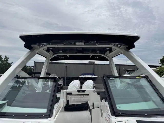 Slide: The Image of 2025 Robalo R257 boat with dual windshields and T-top, docked under cloudy skies. - 10