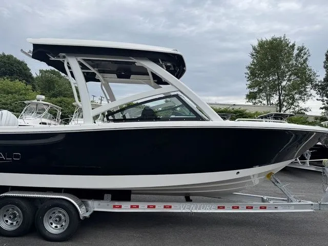 Slide: The Image of 2025 Robalo R257 boat on trailer, sleek black design, overcast sky background. - 15