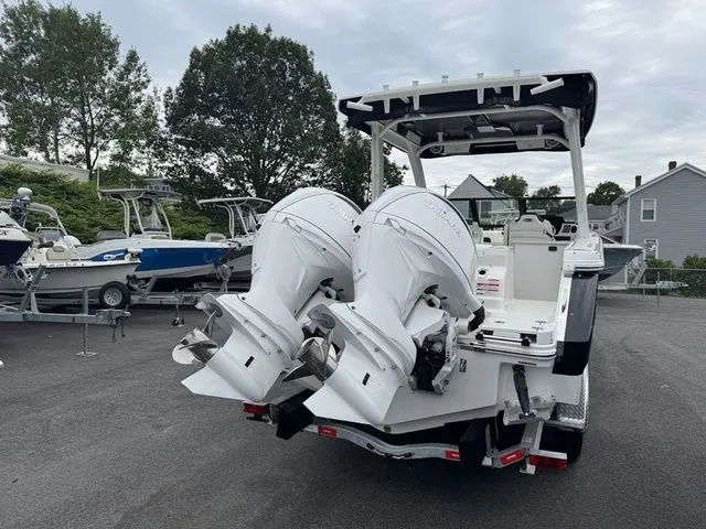 Slide: The Image of 2025 Robalo R257 boat with dual outboard engines, parked outdoors on a cloudy day. - 3