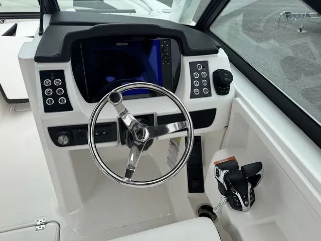 Slide: The Image of 2025 Robalo R257 boat dashboard with steering wheel and control panel. - 8