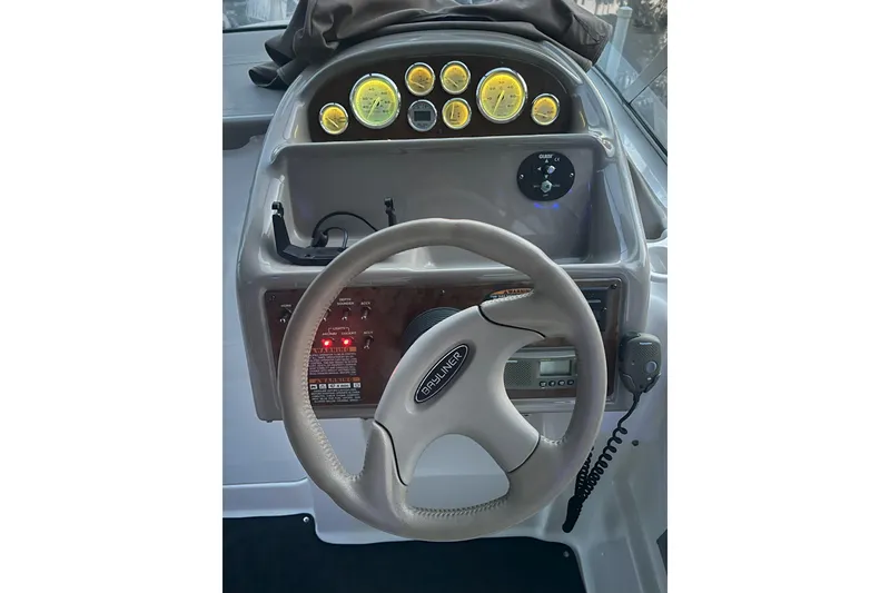 Slide: The Image of 2003 Bayliner 285 boat dashboard with steering wheel and instrument panel. - 14