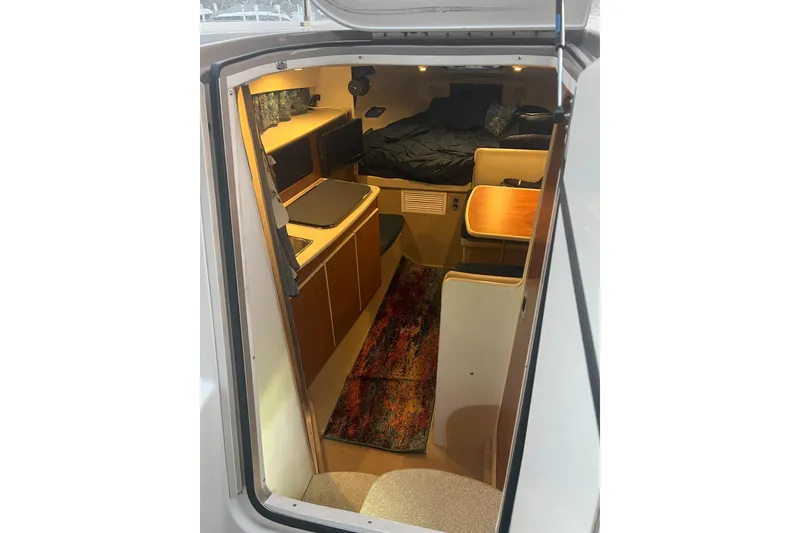 Slide: The Image of Interior view of 2003 Bayliner 285 boat, featuring cozy cabin and seating area. - 15