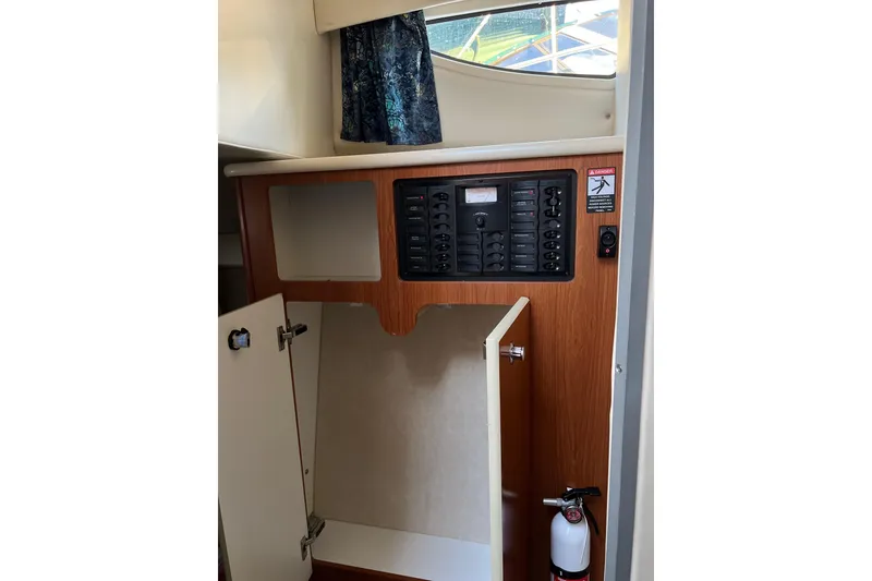 Slide: The Image of 2003 Bayliner 285 interior with control panel and storage cabinet. - 20