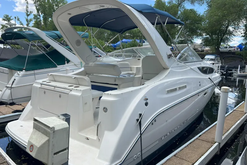 Slide: The Image of 2003 Bayliner 285 boat docked, featuring a sleek white design and spacious seating area. - 7