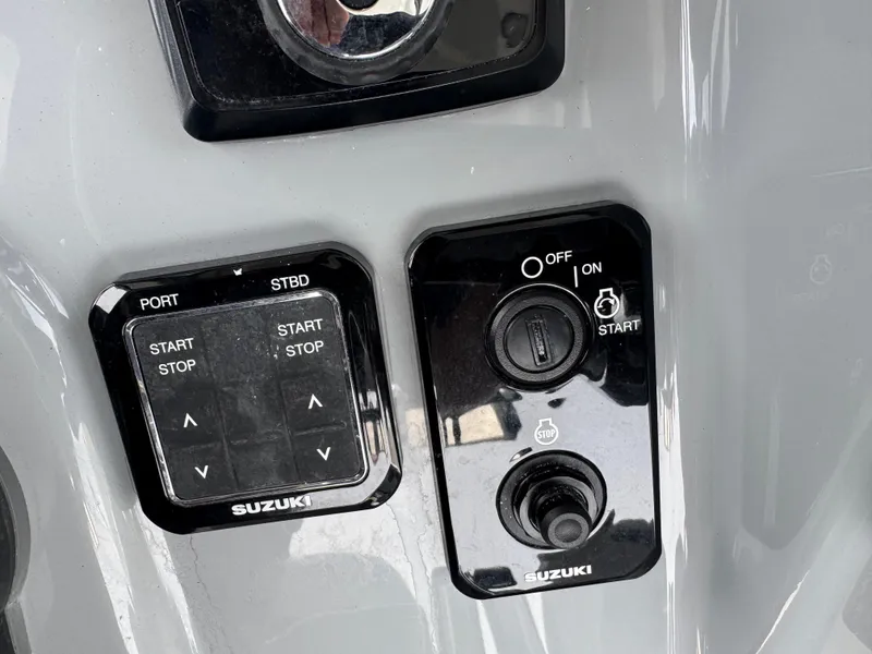 Slide: The Image of Control panel of 2026 Sea Pro 292 DLX boat with Suzuki start-stop buttons. - 10