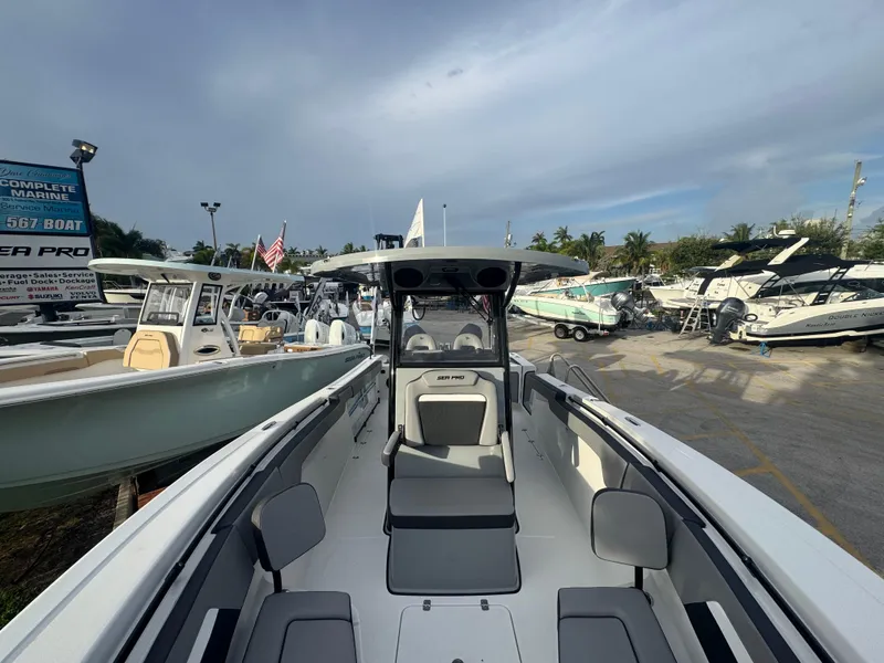 Slide: The Image of 2026 Sea Pro 292 DLX boat displayed at a marina with other vessels. - 28