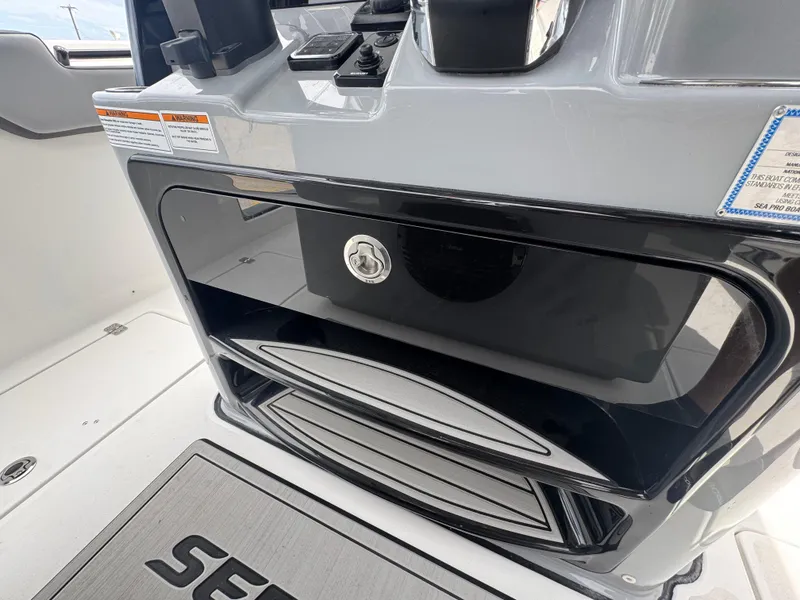 Slide: The Image of 2026 Sea Pro 292 DLX boat console with storage compartment and control panel. - 32