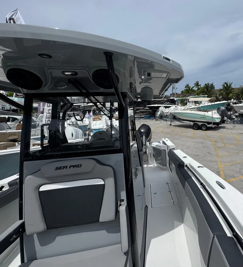 Slide: The Image of 2026 Sea Pro 292 DLX boat interior with seating and console, docked at a marina. - 37