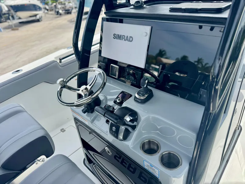 Slide: The Image of 2026 Sea Pro 292 DLX boat console with steering wheel and Simrad display. - 4