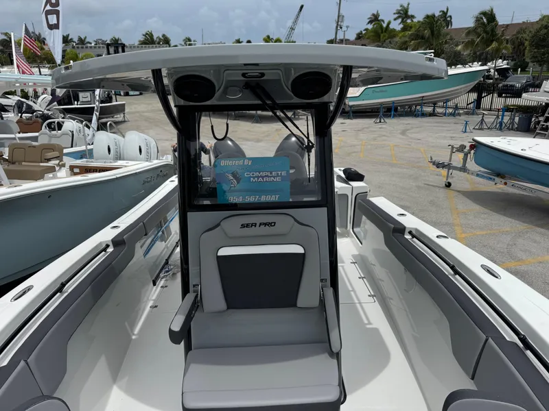 Slide: The Image of 2026 Sea Pro 292 DLX boat interior at a marina, showcasing seating and helm. - 45