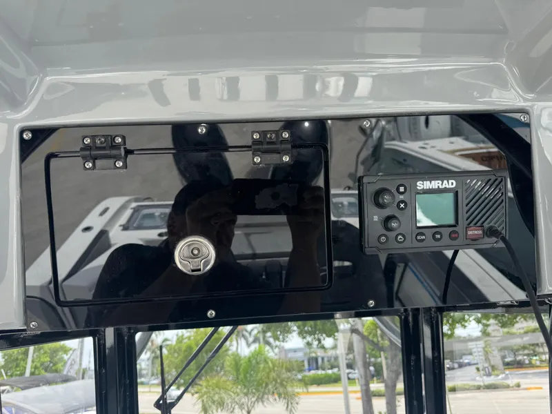 Slide: The Image of 2026 Sea Pro 292 DLX boat dashboard with Simrad navigation system and storage compartment. - 6