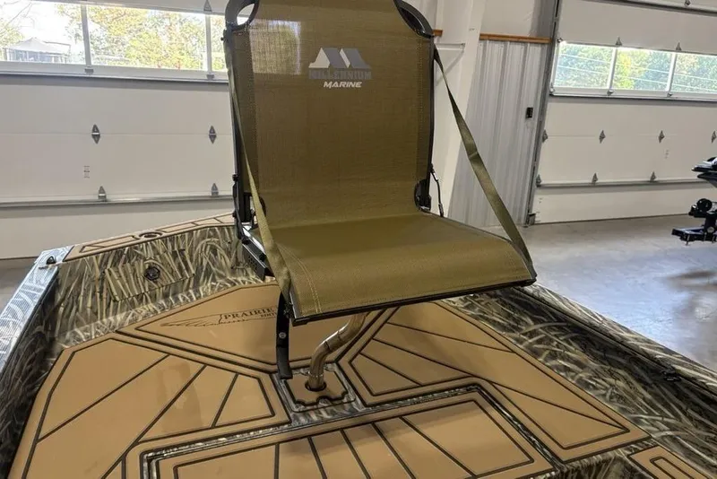 Slide: The Image of 2026 Tracker Grizzly 1650 T Prairie Wings Edition boat with camo seat in garage. - 10