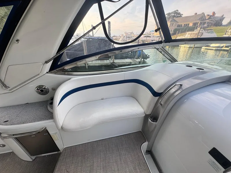 Slide: The Image of Interior of a 2008 Formula 34 PC yacht, featuring white seating and marina view. - 14
