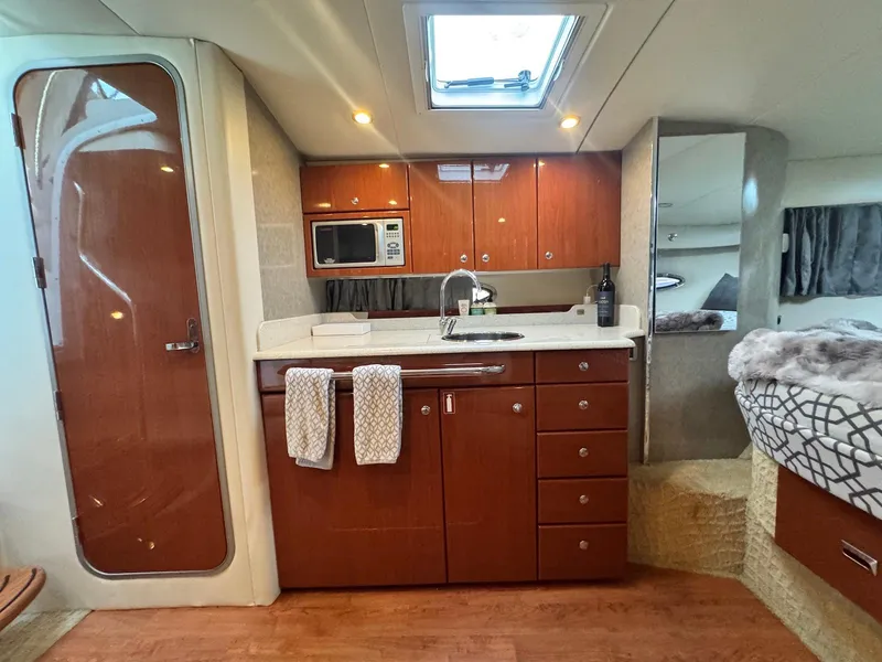 Slide: The Image of 2008 Formula 34 PC yacht interior with kitchenette, wooden cabinets, and cozy sleeping area. - 21