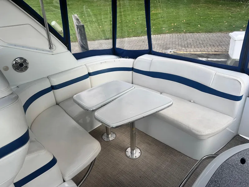 Slide: The Image of 2008 Formula 34 PC boat interior with white and blue seating, dual tables, and carpeted floor. - 5