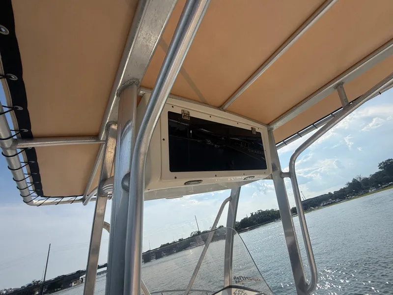 Slide: The Image of 2009 Scout 205 Sportfish boat with canopy and storage compartment, on a sunny day. - 12