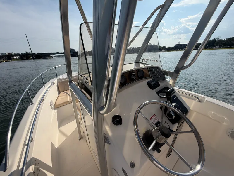 Slide: The Image of 2009 Scout 205 Sportfish boat interior with steering wheel and controls on a sunny day. - 13
