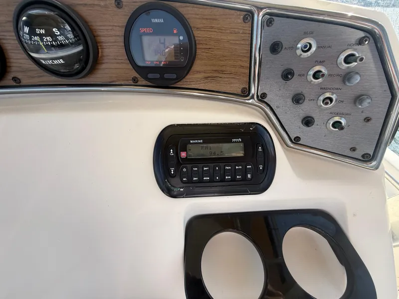 Slide: The Image of 2009 Scout 205 Sportfish dashboard with compass, Yamaha speedometer, and marine radio controls. - 16