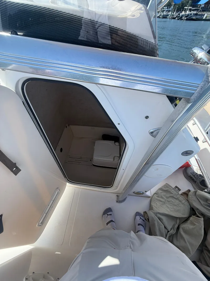 Slide: The Image of 2009 Scout 205 Sportfish boat interior with open storage compartment, dockside view. - 21