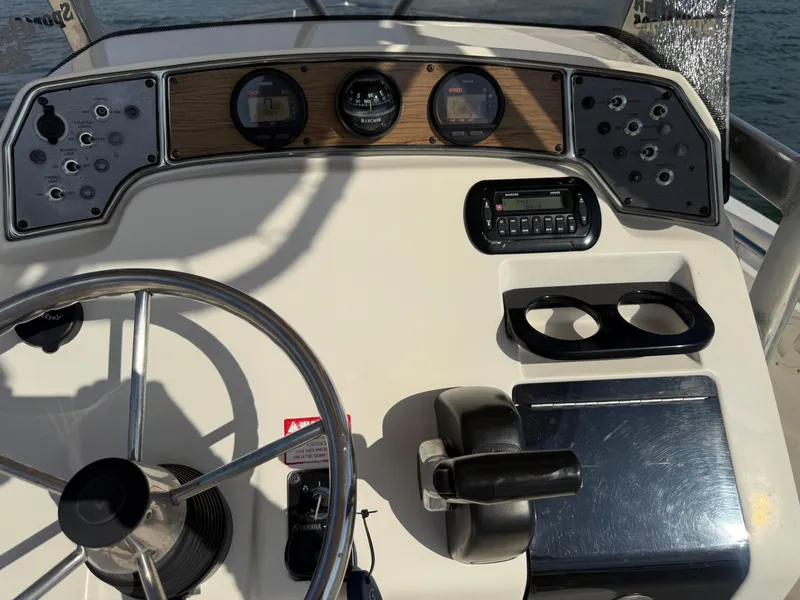 Slide: The Image of 2009 Scout 205 Sportfish boat dashboard with steering wheel and control panel. - 23