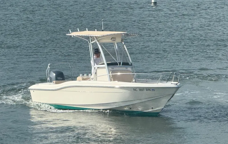 Slide: The Image of 2009 Scout 205 Sportfish boat cruising on water with a person at the helm. - 3