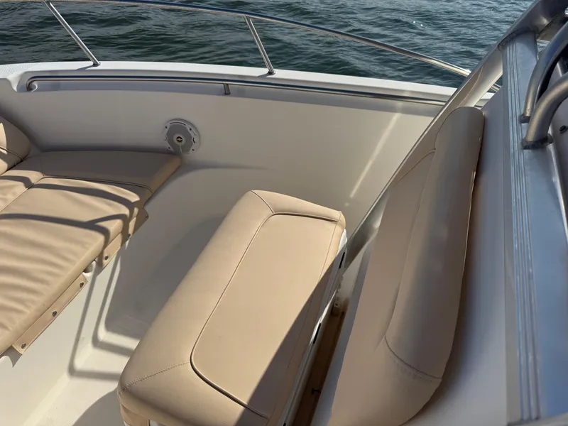 Slide: The Image of 2009 Scout 205 Sportfish boat interior with beige seating and railing, on water. - 30