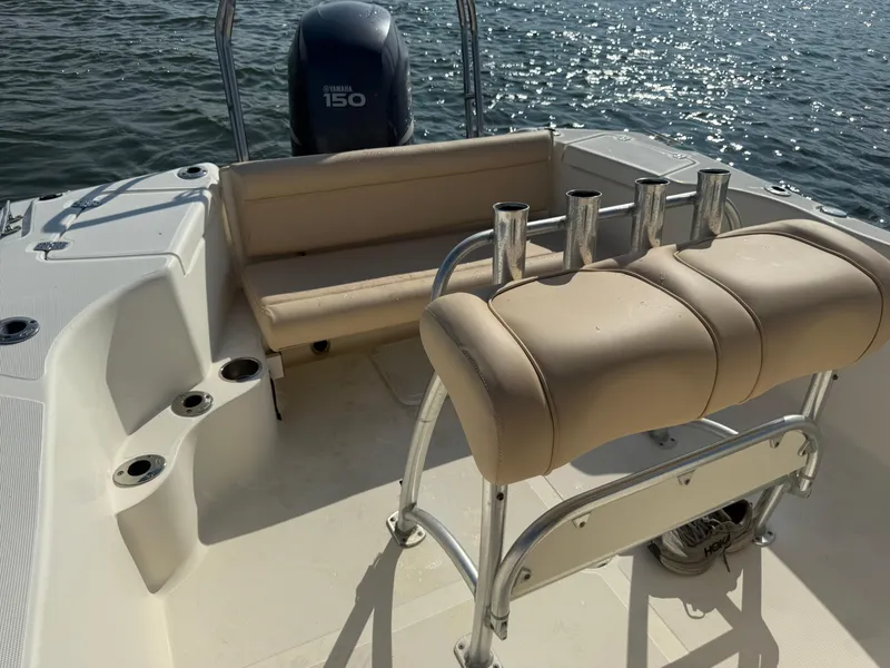 Slide: The Image of 2009 Scout 205 Sportfish boat interior with seating and rod holders on a sunny day. - 33