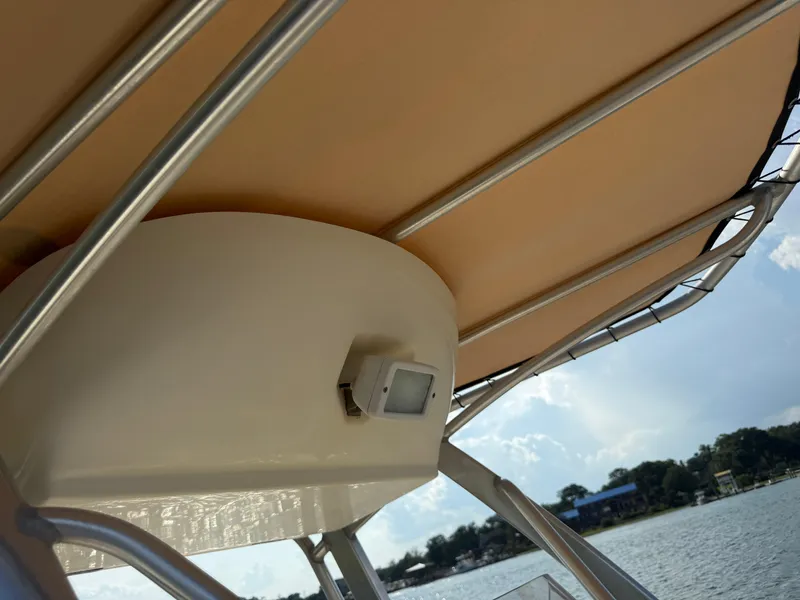 Slide: The Image of 2009 Scout 205 Sportfish boat canopy and light, with scenic lake view. - 34