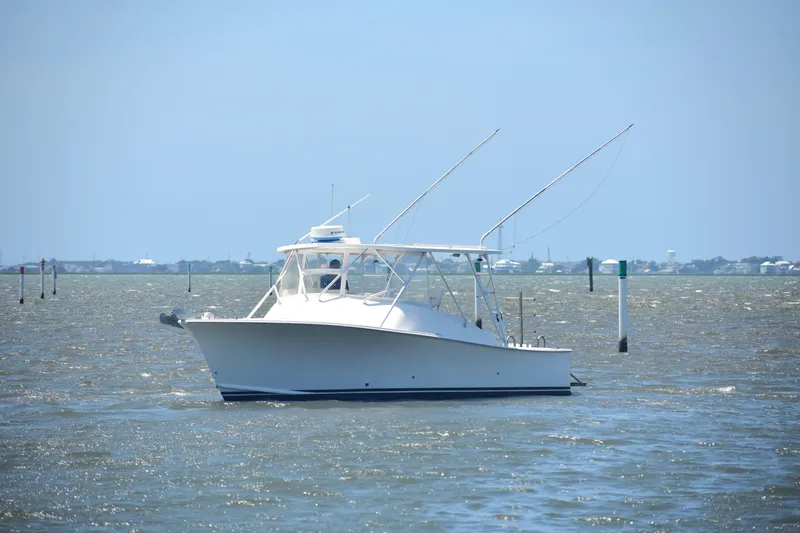 Slide: The Image of 2004 Judge 34 Express boat on calm waters under clear sky. - 1