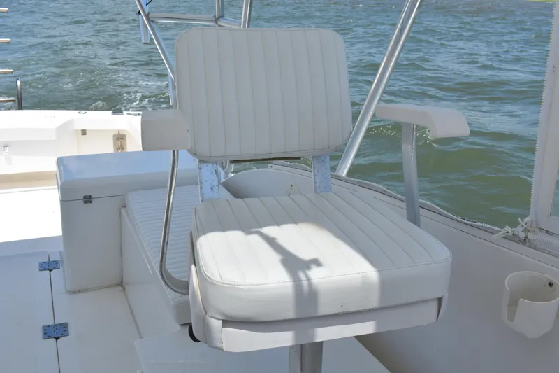 Slide: The Image of White captain's chair on 2004 Judge 34 Express boat, overlooking water. - 13