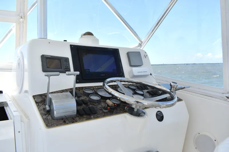 Slide: The Image of 2004 Judge 34 Express boat helm with steering wheel and navigation controls. - 16