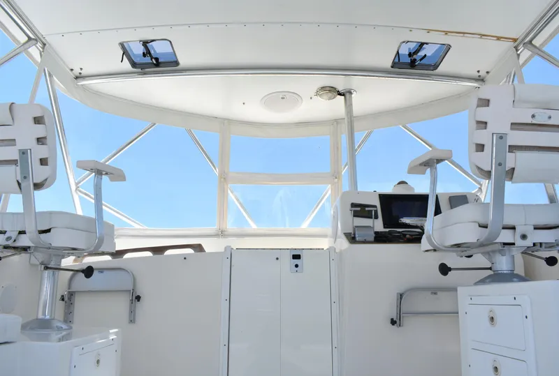 Slide: The Image of Interior view of 2004 Judge 34 Express boat cockpit with white seating and navigation equipment. - 17