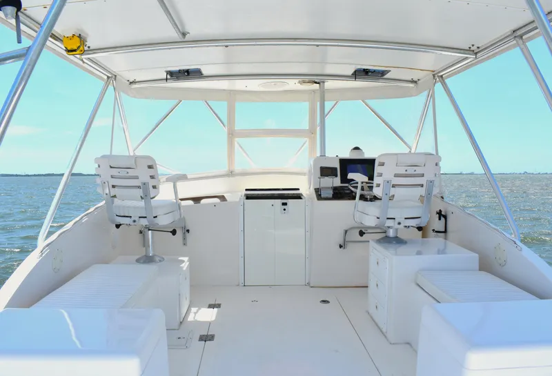 Slide: The Image of 2004 Judge 34 Express boat helm with dual captain chairs on open water. - 18