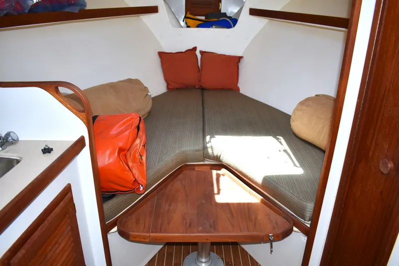 Slide: The Image of 2004 Judge 34 Express cabin interior with cozy bedding and wooden table. - 26