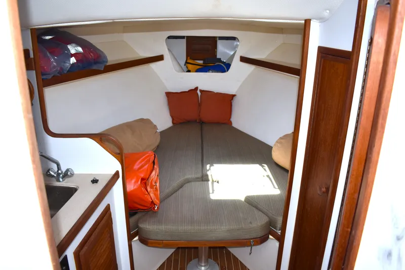 Slide: The Image of 2004 Judge 34 Express cabin interior with cozy bed, sink, and storage. - 27
