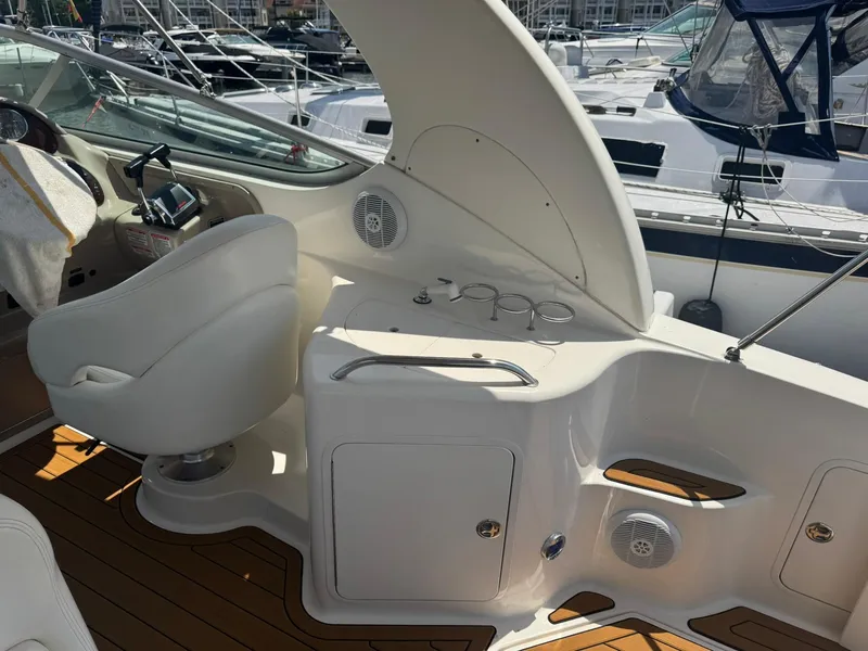 Slide: The Image of 2004 Sea Ray 280 Sundancer cockpit with helm, seating, and storage compartments. - 11