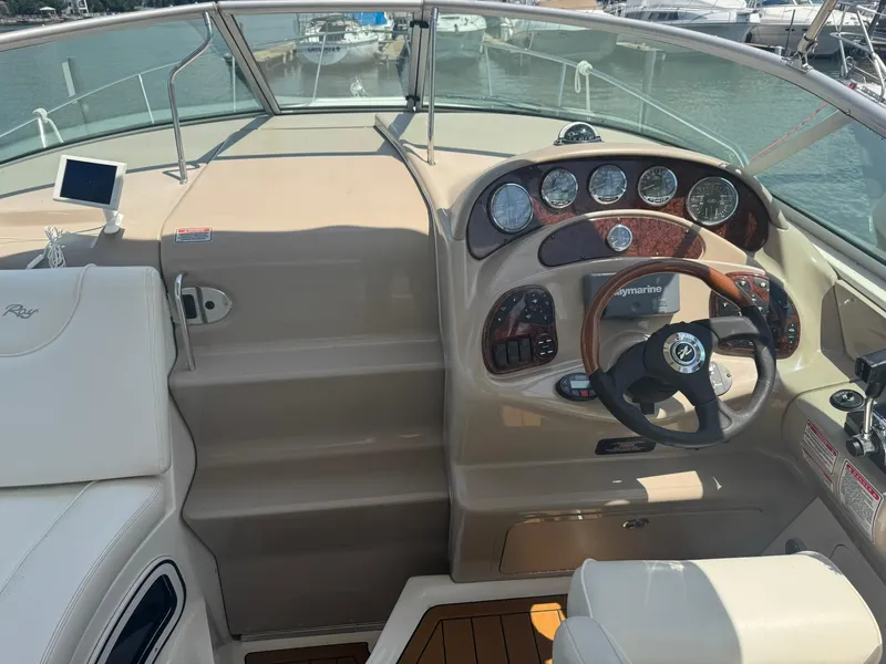 Slide: The Image of 2004 Sea Ray 280 Sundancer helm with gauges, steering wheel, and navigation equipment. - 13