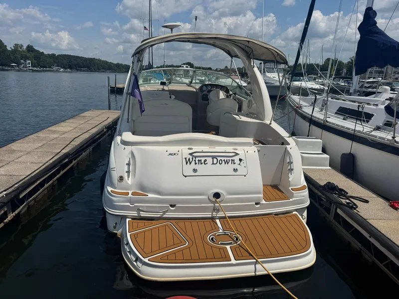 Slide: The Image of 2004 Sea Ray 280 Sundancer docked, rear view with "Wine Down" nameplate. - 2