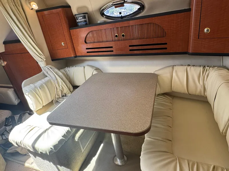 Slide: The Image of Interior of 2004 Sea Ray 280 Sundancer with cozy seating and wooden cabinetry. - 22