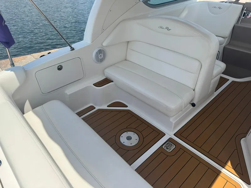 Slide: The Image of 2004 Sea Ray 280 Sundancer interior with white seating and teak flooring. - 9