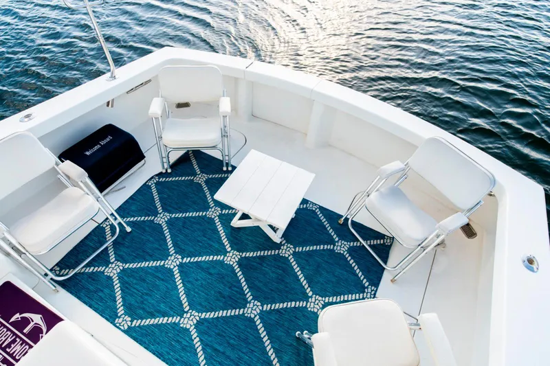 Slide: The Image of Boat deck with chairs, table, and blue patterned rug on water. Post 42, 2008 model. - 23