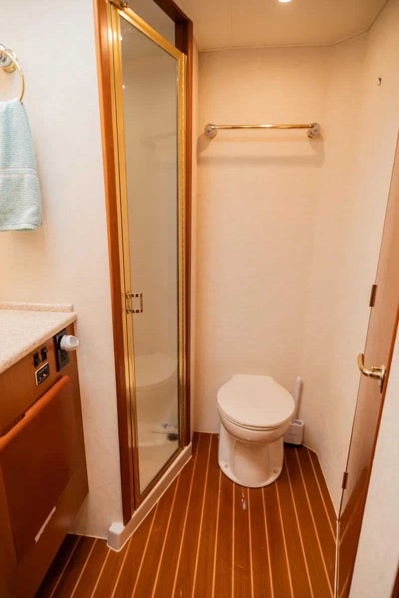 Slide: The Image of Compact bathroom with shower, toilet, and wooden flooring in a 2008 Post 42 model. - 41