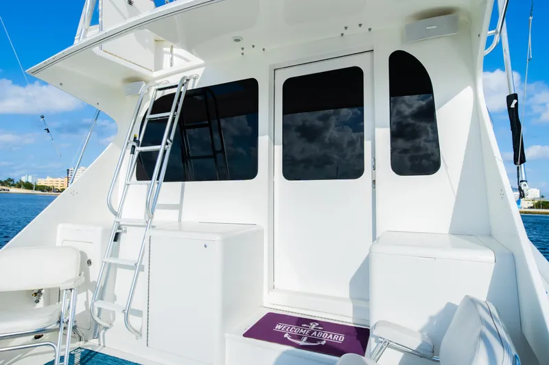 Slide: The Image of 2008 Post 42 yacht deck with ladder and seating, under clear blue sky. - 25